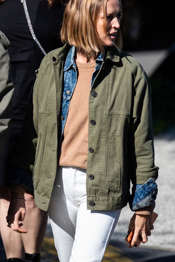 Layered Spring Outfit Idea — Army green jacket, camel sweater, denim jacket, and white jeans.